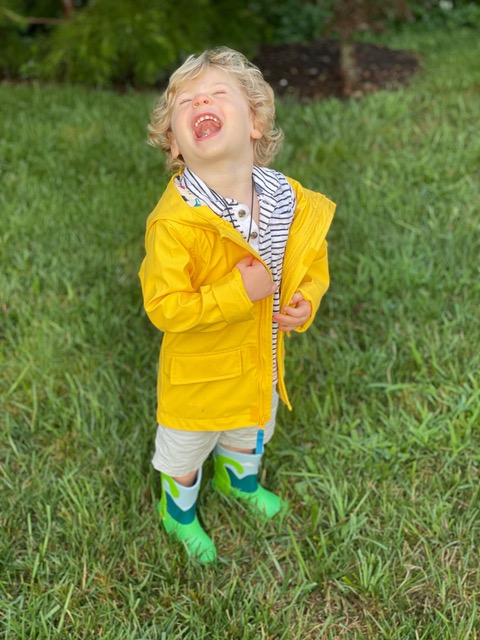 Little boy wearing a bright yellow rain jacket.